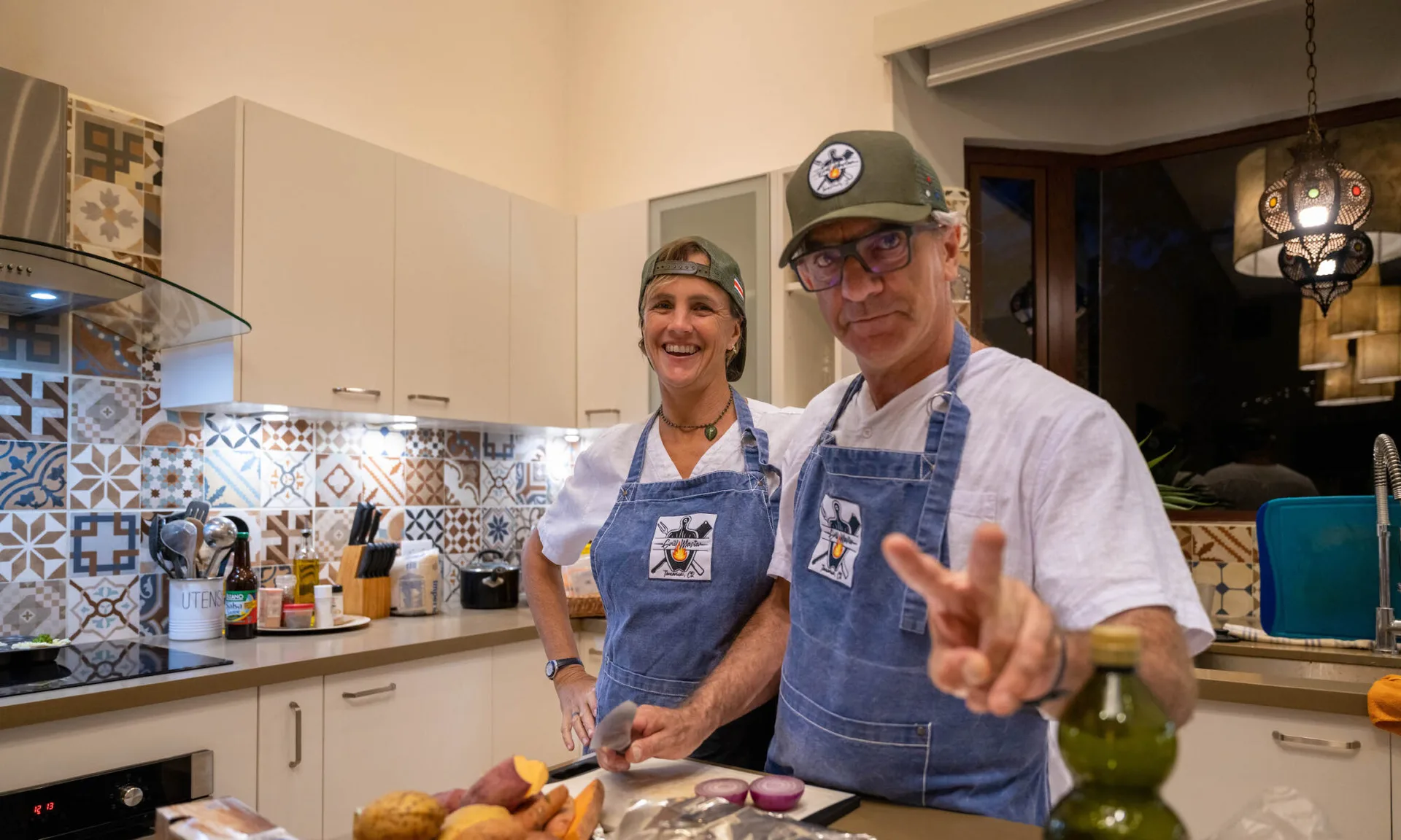 Hernán and Diana, private chefs of Grill Master Tamarindo, plating a flame-grilled dinner