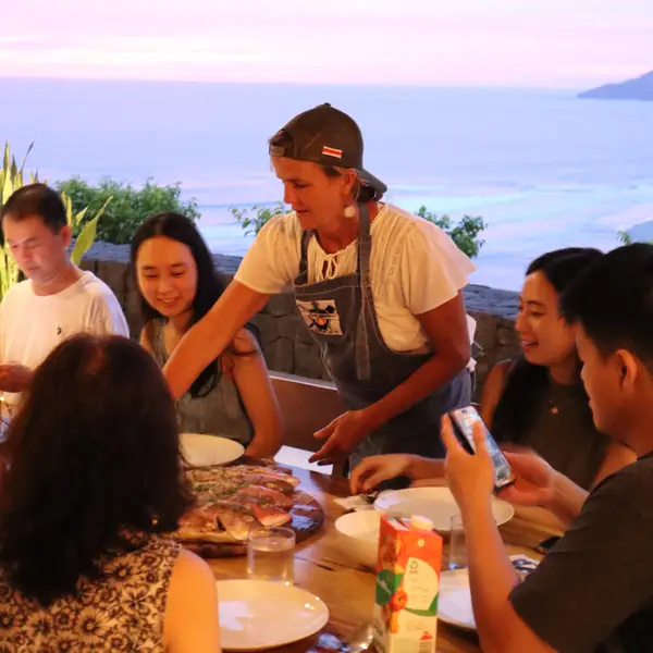 Serving a private chef dinner to guests at an ocean-view home
