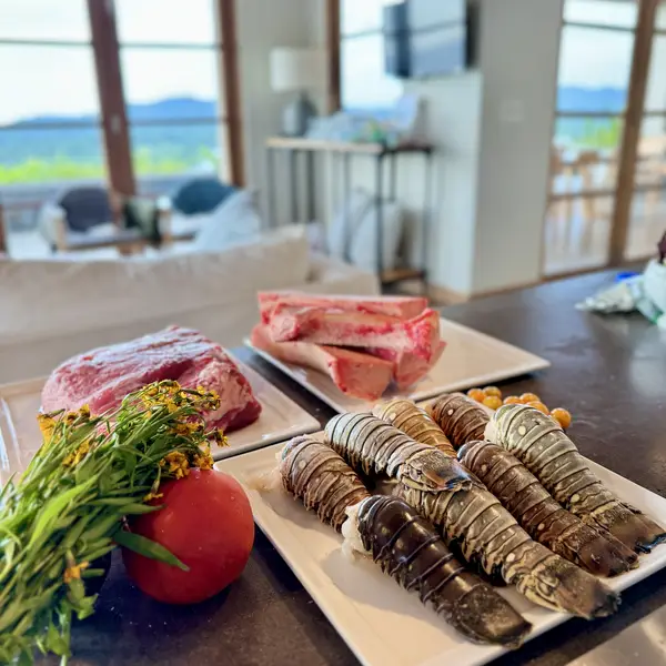 Lobster tails and steaks prepped for the grill at a vacation home
