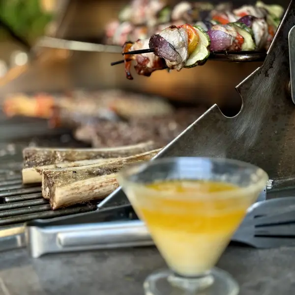 Skewers on the grill with a welcome drink