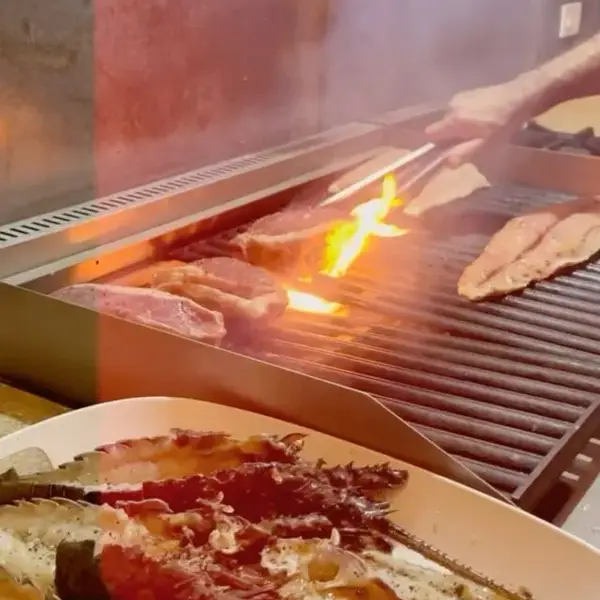 Fish and bacon cooking on the grill