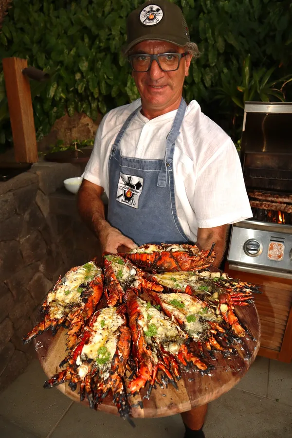 Hernán Heredia holding a platter of grilled lobster, private chef in Tamarindo